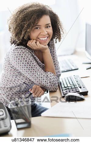 Young woman working at office View Large Photo Image Stock Photo - Young woman working at office. Fotosearch