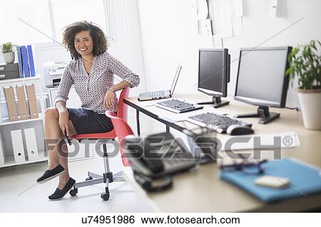 Young woman working at office View Large Photo Image Stock Photograph - Young woman working at office. Fotosearch
