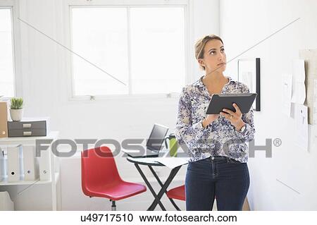Young woman working in office View Large Photo Image Stock Image - Young woman working in office. Fotosearch