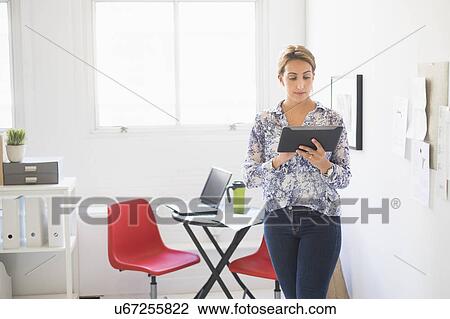 Young woman working in office View Large Photo Image Stock Image - Young woman working in office. Fotosearch