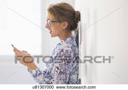 Stock Image - Young woman working in office. Fotosearch