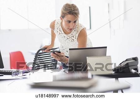 Young woman working in office View Large Photo Image Stock Photo - Young woman working in office. Fotosearch
