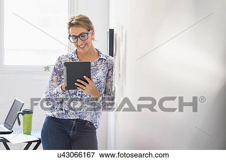 Stock Photo - Young woman working in office. Fotosearch