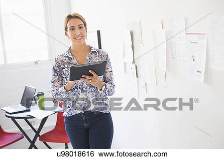 Stock Photograph - Young woman working in office. Fotosearch