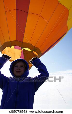 Stock Photo -  albq balloon fiesta girl child kid holding up. Fotosearch