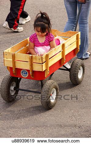 baby latino hispanic girl being pulled in red View Large Photo Image Stock Photo - baby latino hispanic girl being pulled in red. Fotosearch