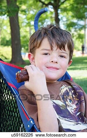 Stock Photograph -  boy male kid child in stroller smiling cake kids. Fotosearch