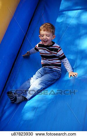 Stock Image -  boy sliding down plastic slide happy fun new. Fotosearch