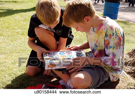 Picture -  boys children kids looking a game box toy. Fotosearch