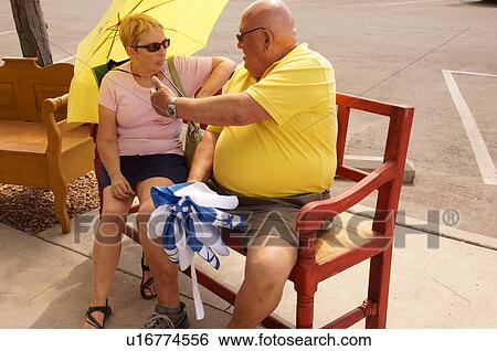 Stock Photograph -  couple senior citizen aged sitting on bench. Fotosearch