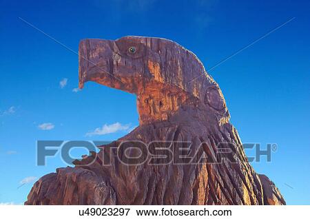 Stock Photo -  eagle watching wood sculpture blue sky southwest. Fotosearch