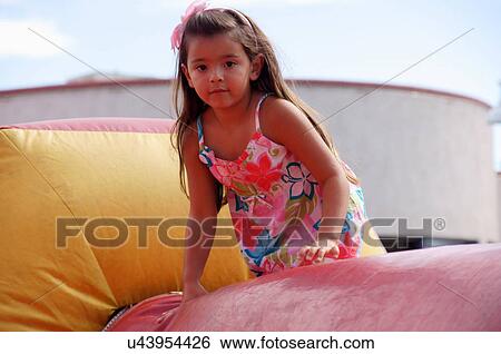 Stock Photograph -  girl child kid inflatable bounce house latino. Fotosearch