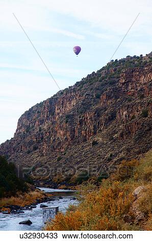 Stock Image -  hot-air hot air balloon and cliffs rio grand. Fotosearch