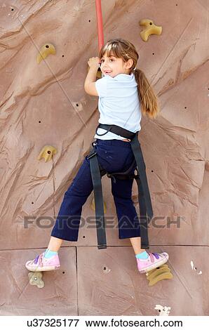 Stock Photo -  little girl child kid rock climbing climb skill. Fotosearch