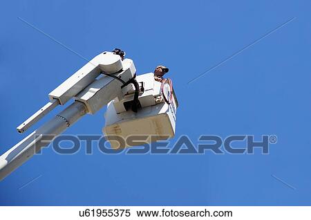 Stock Photography -  man male in lift dolly blue sky work electric. Fotosearch