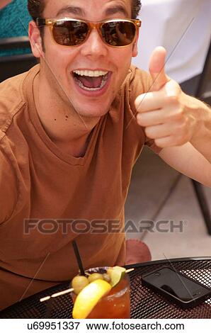 Stock Photo -  man male with cocktail drink alcohol laughing up. Fotosearch