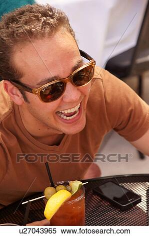 Stock Photography -  man male with cocktail drink alcohol laughing. Fotosearch