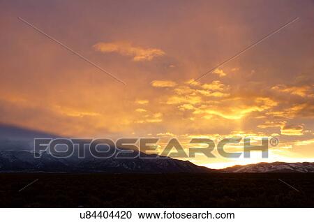 Stock Image -  sunrise dawn fog mist taos mountains new mexico. Fotosearch