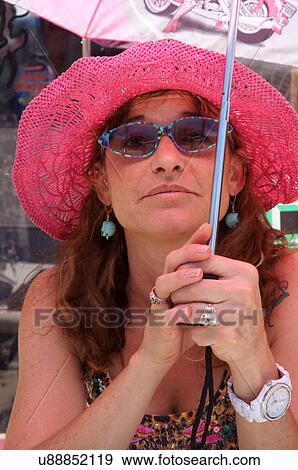 Stock Photo -  woman female with pink hat and umbrella glasses. Fotosearch