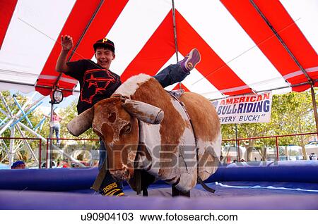 young boy is thrown from a mechanical bull rider View Large Photo Image Stock Image - young boy is thrown from a mechanical bull rider. Fotosearch