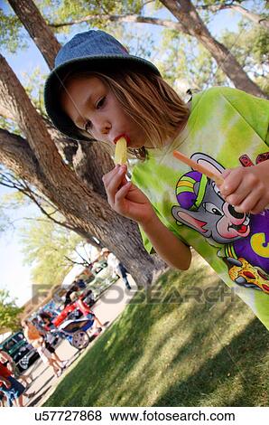 Stock Photo -  young caucasion girl child kid eating popcicle. Fotosearch