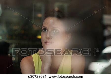 A young brunette woman sitting in a cafe looking out of the window View Large Photo Image Stock Image - A young brunette woman sitting in a cafe looking out of the window. Fotosearch