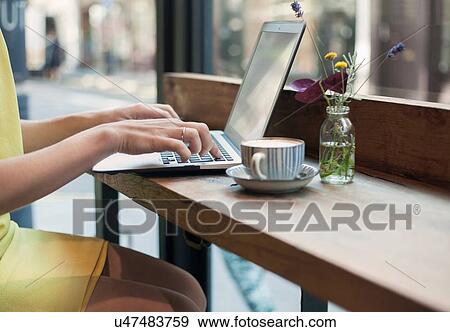 A young woman sitting in a cafe working View Large Photo Image Stock Photo - A young woman sitting in a cafe working. Fotosearch