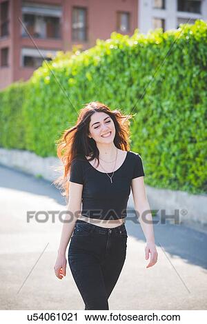 Beautiful young woman with long brown hair strolling View Large Photo Image Stock Image - Beautiful young woman with long brown hair strolling. Fotosearch