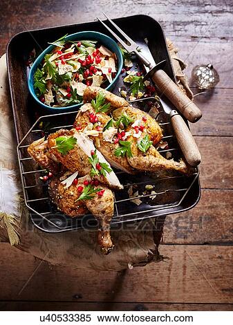 Stock Photography - Butterflied chicken zaatar with pomegranate. Fotosearch