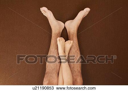 Stock Image - Child's legs on man's legs. Fotosearch