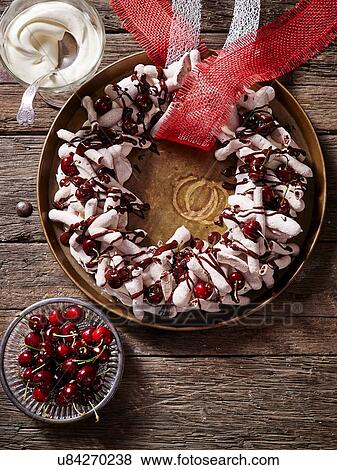 Stock Photo - Chocolate meringue wreath with cherries. Fotosearch