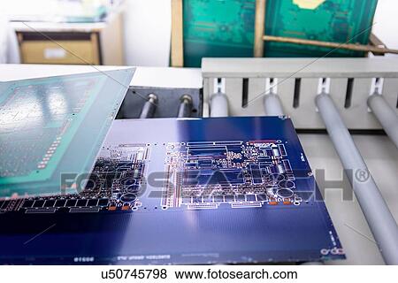 Stock Photo - Circuit boards in processing machine in circuit board factory. Fotosearch