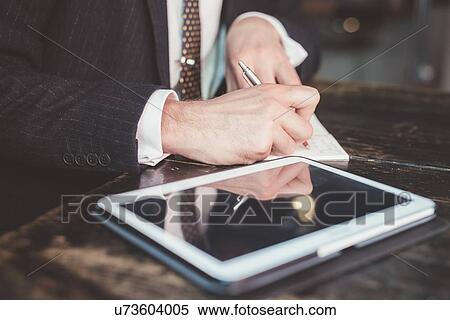 Close up of businessman making diary notes at table View Large Photo Image Stock Photography - Close up of businessman making diary notes at table. Fotosearch