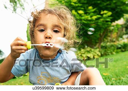 Close up portrait of cute girl blowing bubbles in garden View Large Photo Image Stock Photo - Close up portrait of cute girl blowing bubbles in garden. Fotosearch