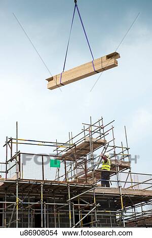 Picture - Construction worker on roof of building site. Fotosearch