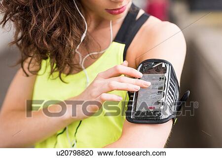 Cropped close up of female runner choosing music on smartphone armband View Large Photo Image Stock Image - Cropped close up of female runner choosing music on smartphone armband. Fotosearch