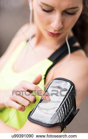 Cropped shot of female runner choosing music on smartphone armband View Large Photo Image Stock Image - Cropped shot of female runner choosing music on smartphone armband. Fotosearch