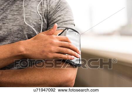 Cropped shot of male runner choosing music on smartphone armband View Large Photo Image Stock Image - Cropped shot of male runner choosing music on smartphone armband. Fotosearch
