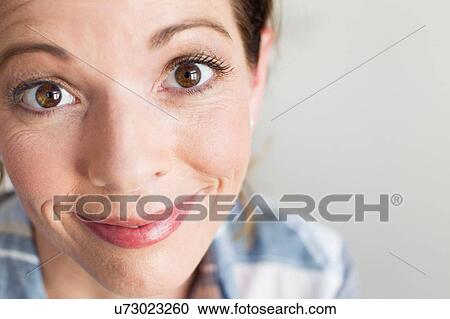 Stock Image - Cropped view of brown eye mature woman looking at camera smiling. Fotosearch