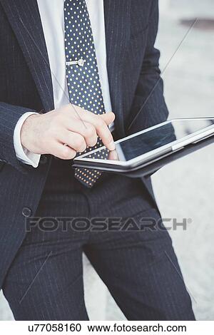 Cropped view of businessman using digital tablet touchscreen View Large Photo Image Stock Image - Cropped view of businessman using digital tablet touchscreen. Fotosearch