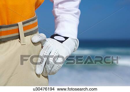Cropped view of golfer wearing golf gloves hand on hip View Large Photo Image Picture - Cropped view of golfer wearing golf gloves hand on hip. Fotosearch