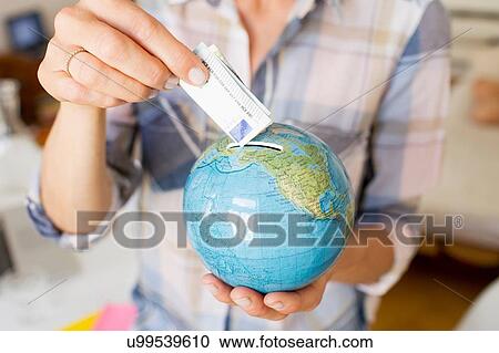 Cropped view of mature womans hands inserting money into globe money box View Large Photo Image Stock Image - Cropped view of mature womans hands inserting money into globe money box. Fotosearch