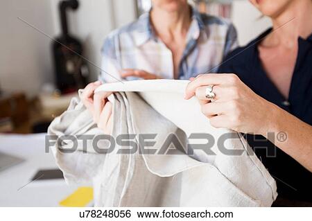 Cropped view of mature women holding and inspecting fabric View Large Photo Image Stock Photograph - Cropped view of mature women holding and inspecting fabric. Fotosearch