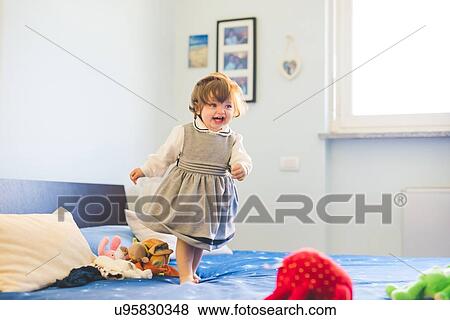 Cute female toddler toddling on bed View Large Photo Image Stock Photo - Cute female toddler toddling on bed. Fotosearch