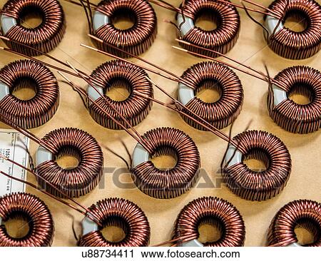 Stock Image - Electromagnetic coils on production line in electromagnetics factory, close-up. Fotosearch