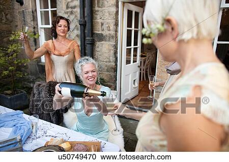 Elegant mature women enjoying champagne in urban garden View Large Photo Image Stock Image - Elegant mature women enjoying champagne in urban garden. Fotosearch