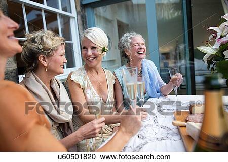 Elegant mature women enjoying champagne in urban garden View Large Photo Image Stock Image - Elegant mature women enjoying champagne in urban garden. Fotosearch