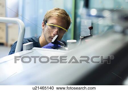 Stock Image - Factory engineer checking equipment in factory. Fotosearch