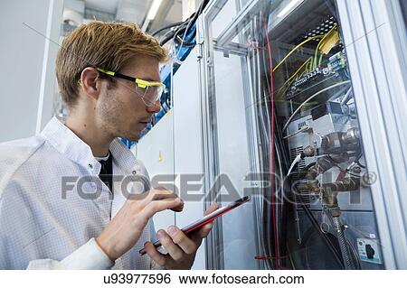 Factory technician inspecting equipment using digital tablet View Large Photo Image Stock Photograph - Factory technician inspecting equipment using digital tablet. Fotosearch
