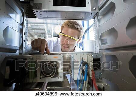 Factory technician inspecting machine electronics View Large Photo Image Stock Photograph - Factory technician inspecting machine electronics. Fotosearch